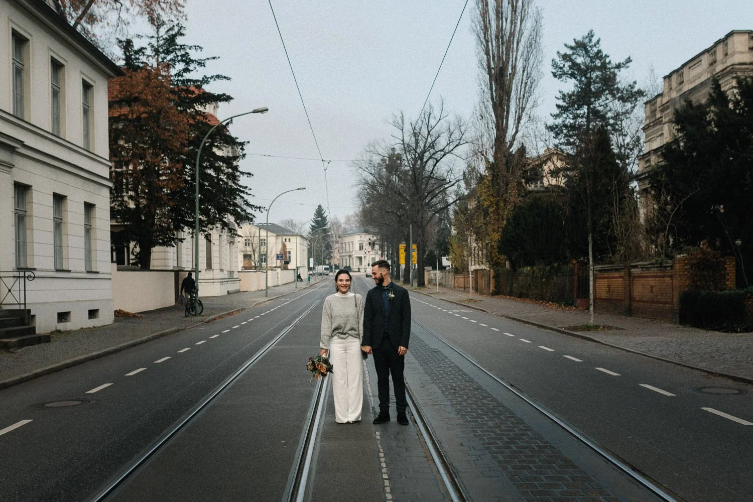 Brautpaar in Potsdam steht mittig auf einer Straße