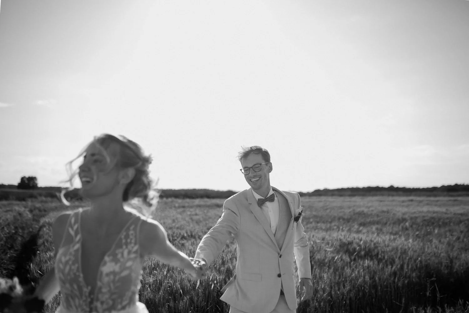 Brautpaar rennt durch ein Kornfeld im Sommer, Schwarz Weiß Foto