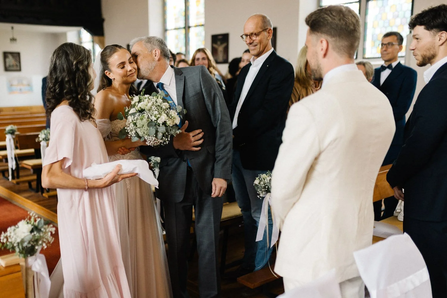 Brauteltern übergeben Braut an Bräutigam, Brautvater küsst Braut auf Wange