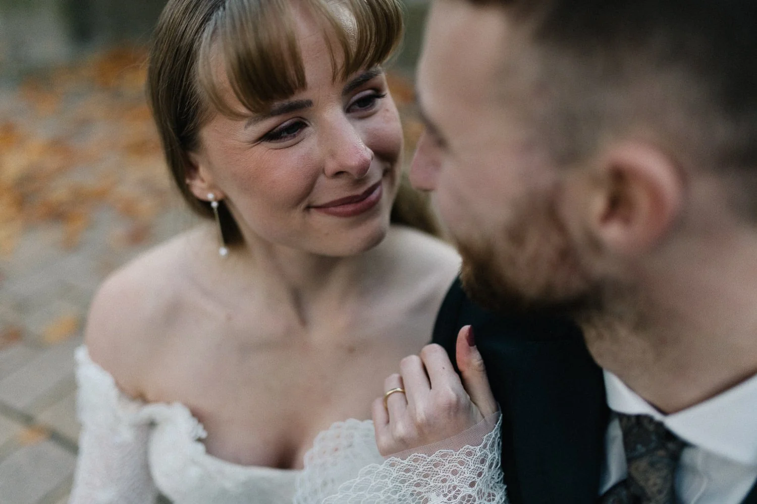 Paarshooting am Hochzeitstag, Brautpaar sitzt nebeneinander und schaut sich an