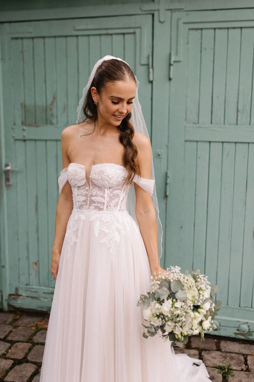 Portrait Braut mit Brautstrauß vor grüner Tür