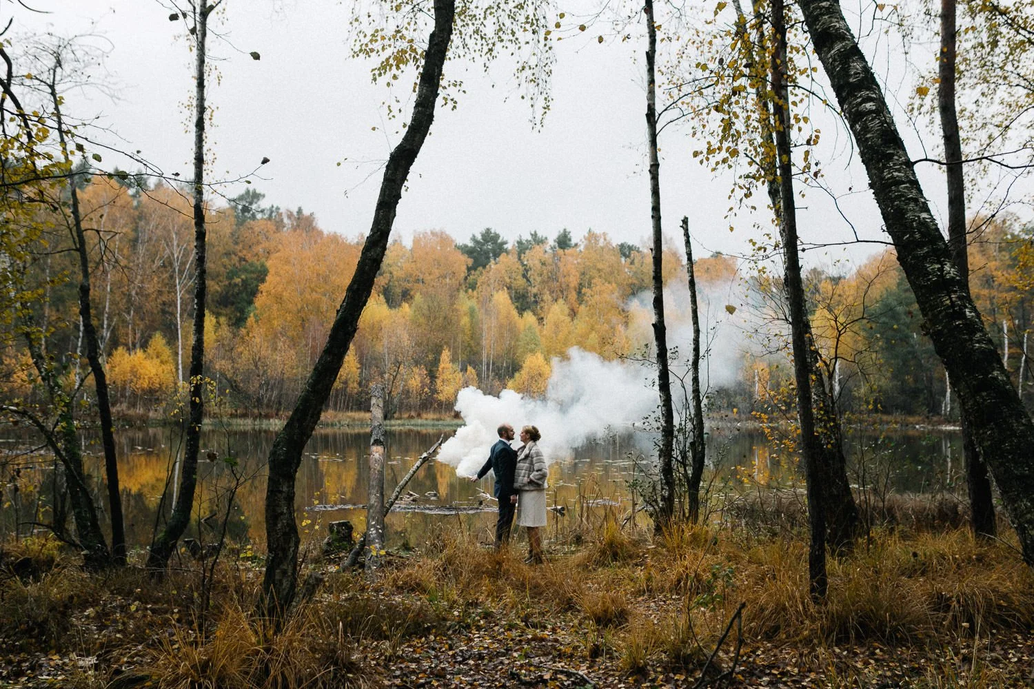 Brautpaar von hinten an See im Herbst, Pyrotechnik