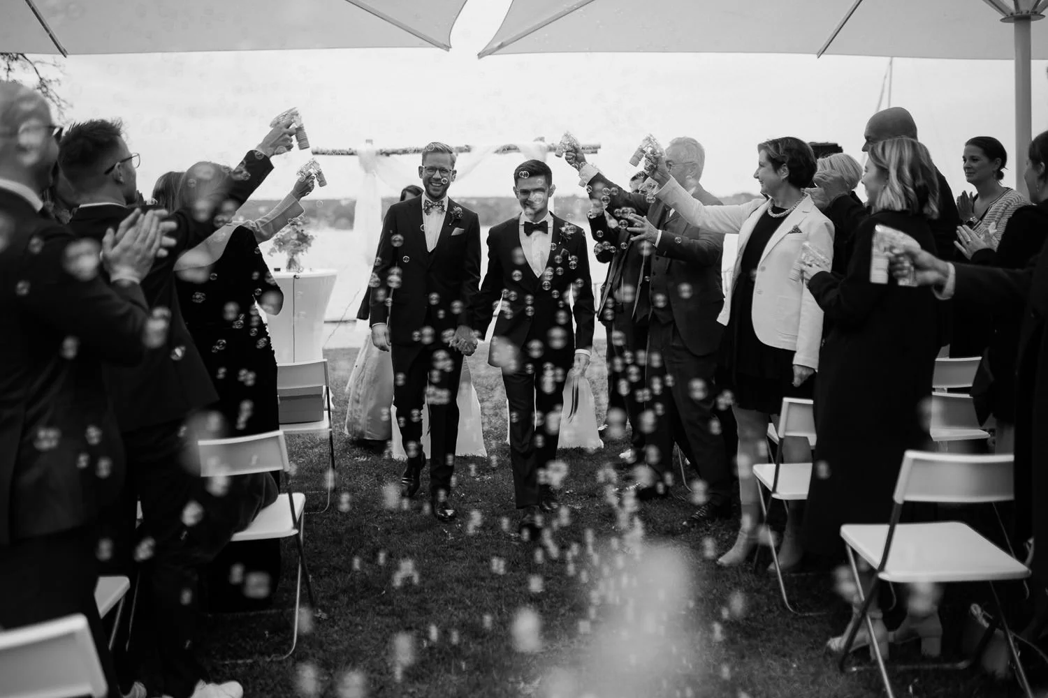 Auszug LGBTQ Trauung in Garten von Villa Blumenfisch, Seifenblasen, Hochzeitsfotograf Potsdam, Schwarzweiß Foto