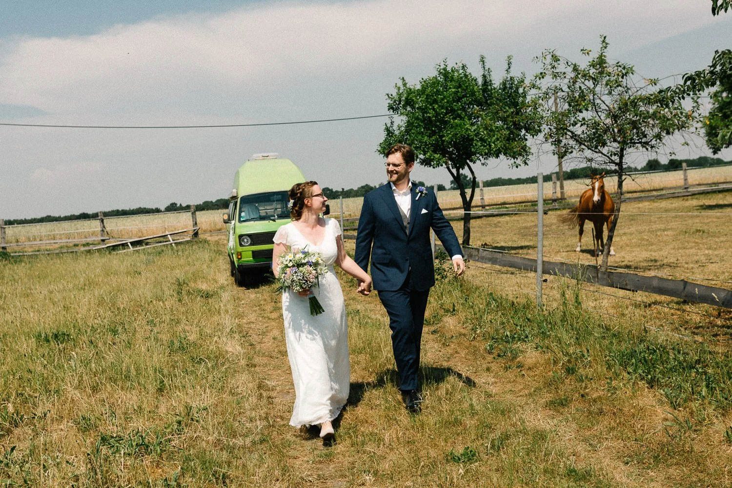 Brautpaar läuft Feldweg entlang