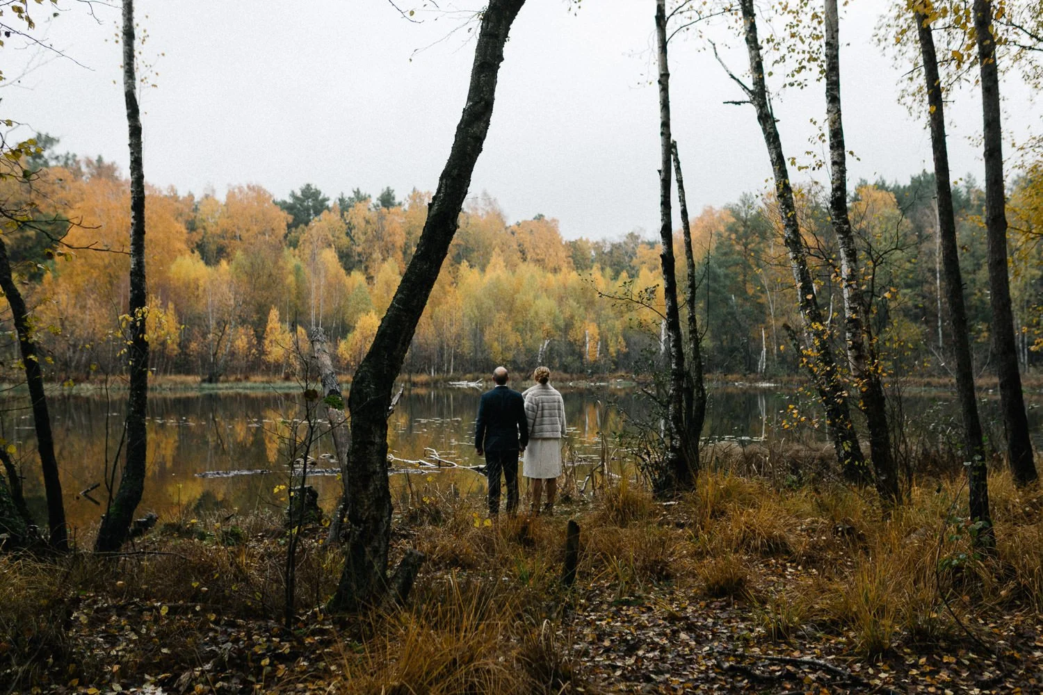 Brautpaar von hinten an See im Herbst