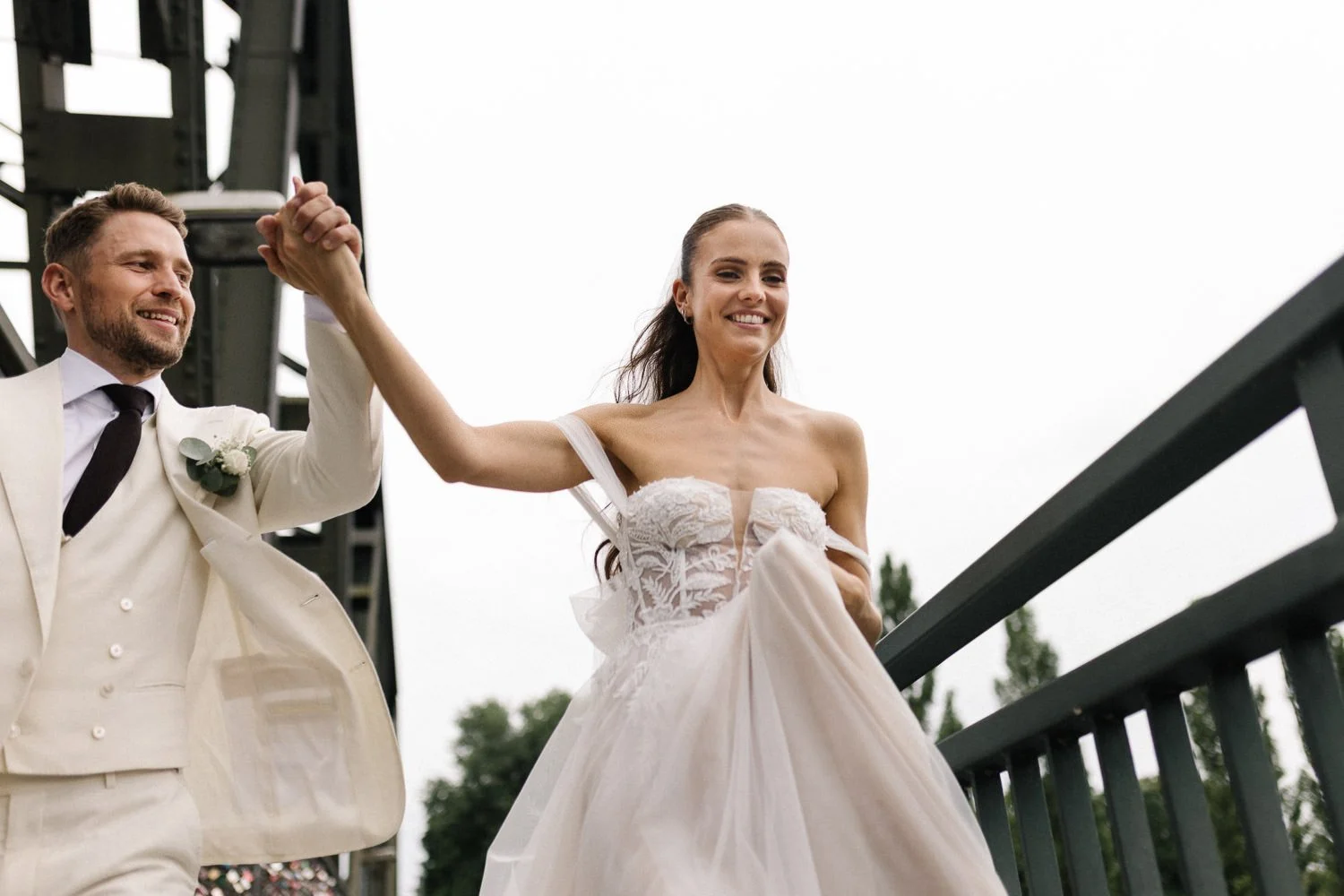 Brautpaar rennend und lachend, von unten fotografiert