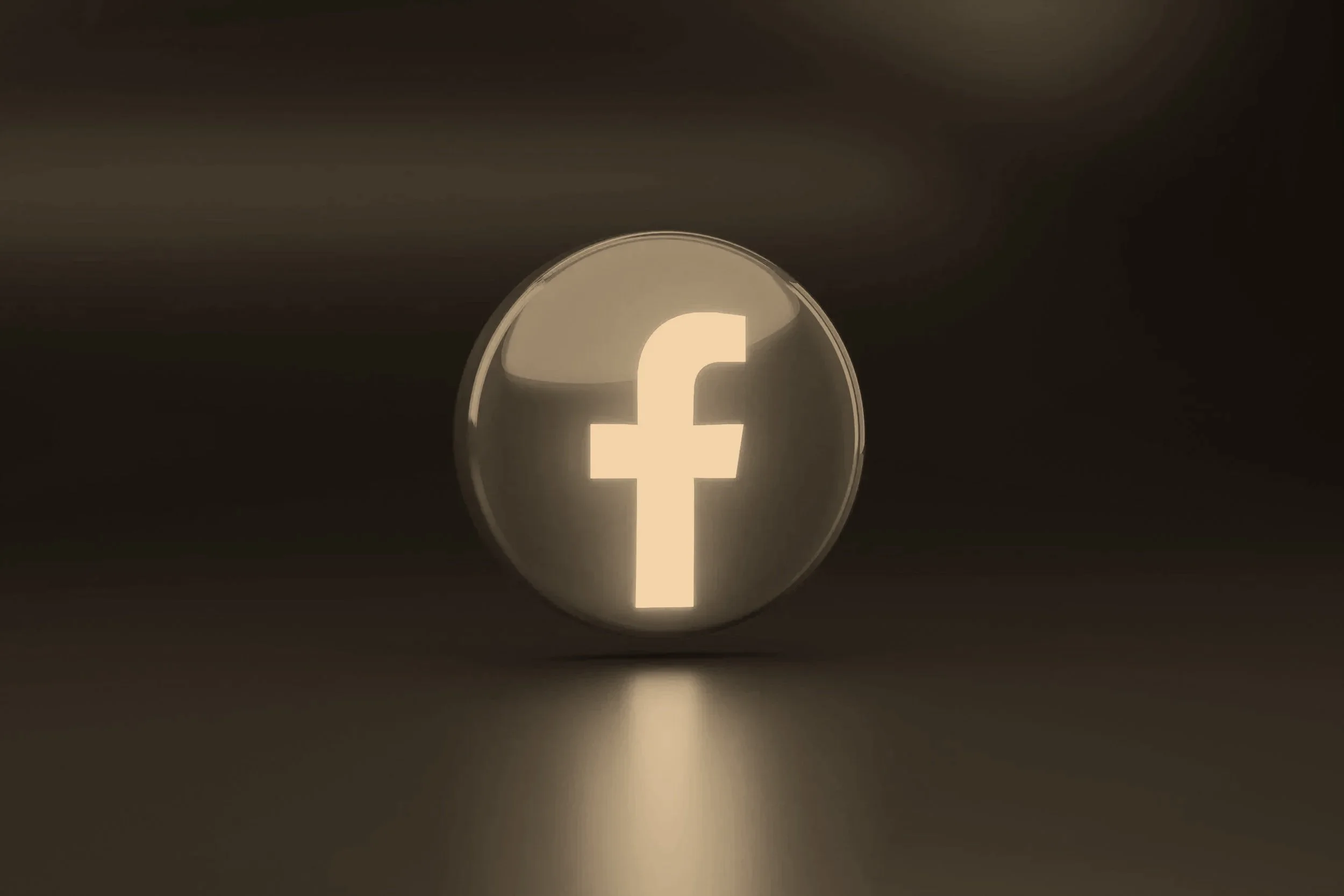 A glowing white Facebook logo on a dark background, with a reflective surface underneath.