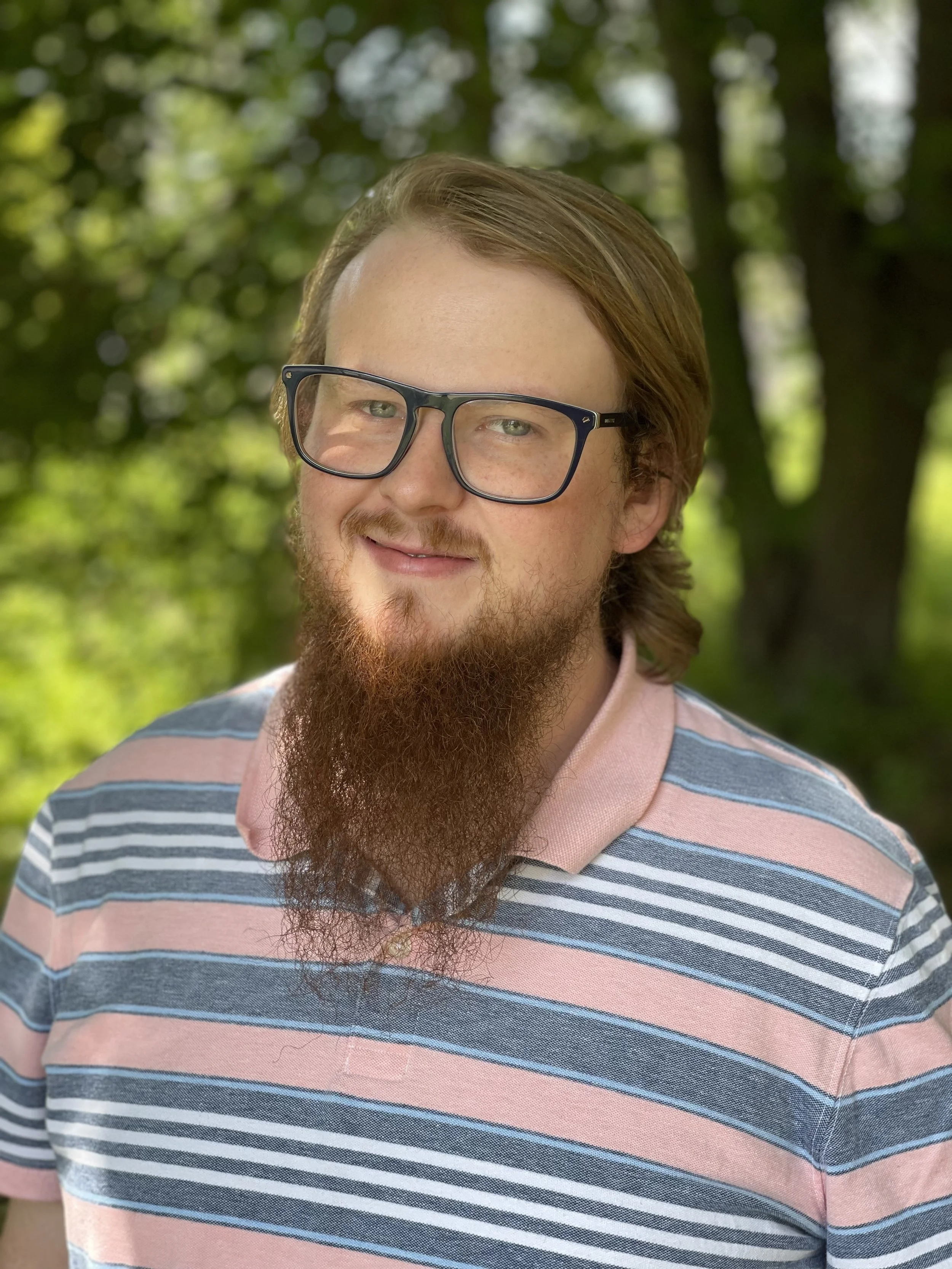 alexander ringo wearing glasses and a striped polo