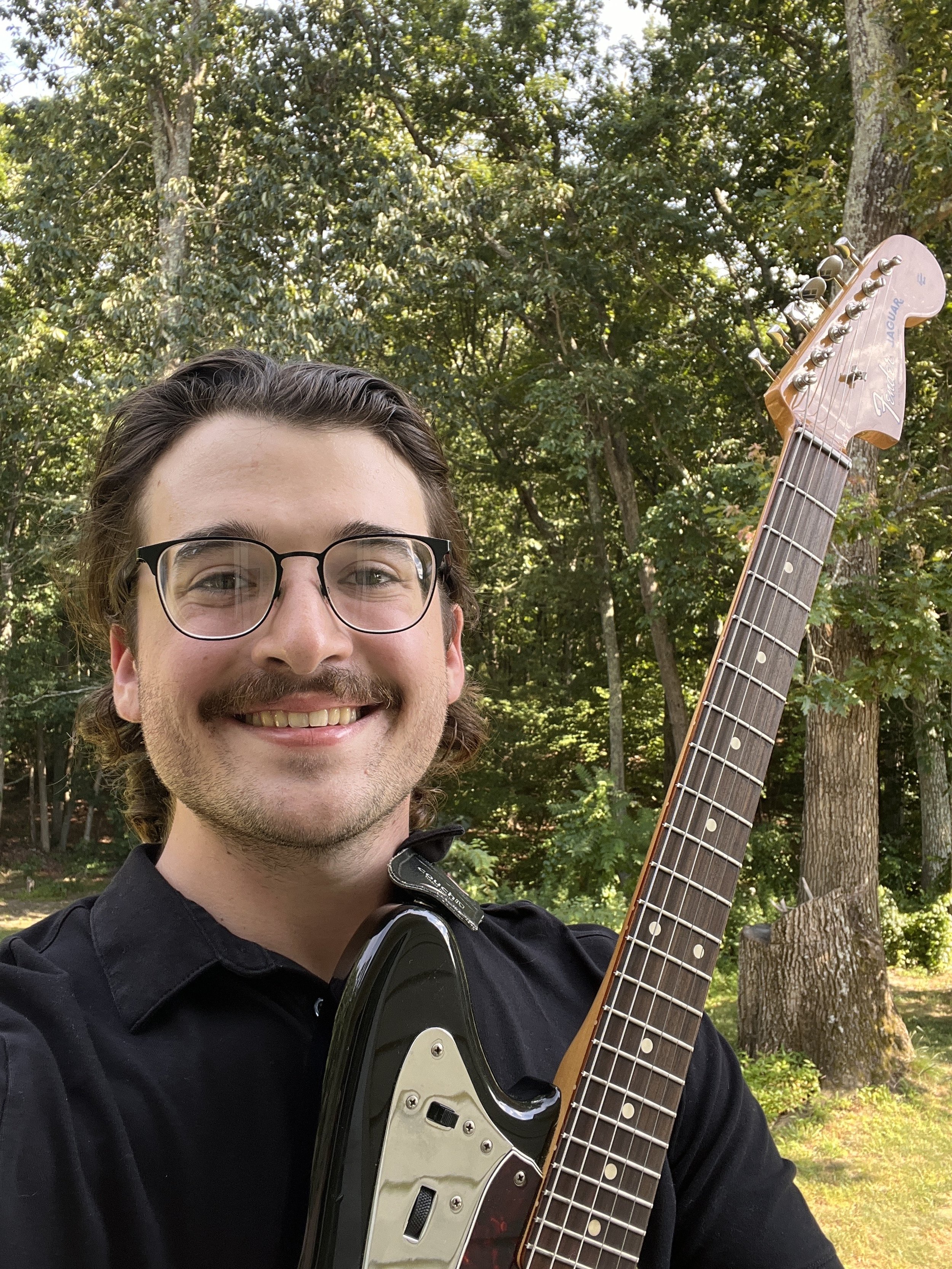 David Marshall holding a guitar outside