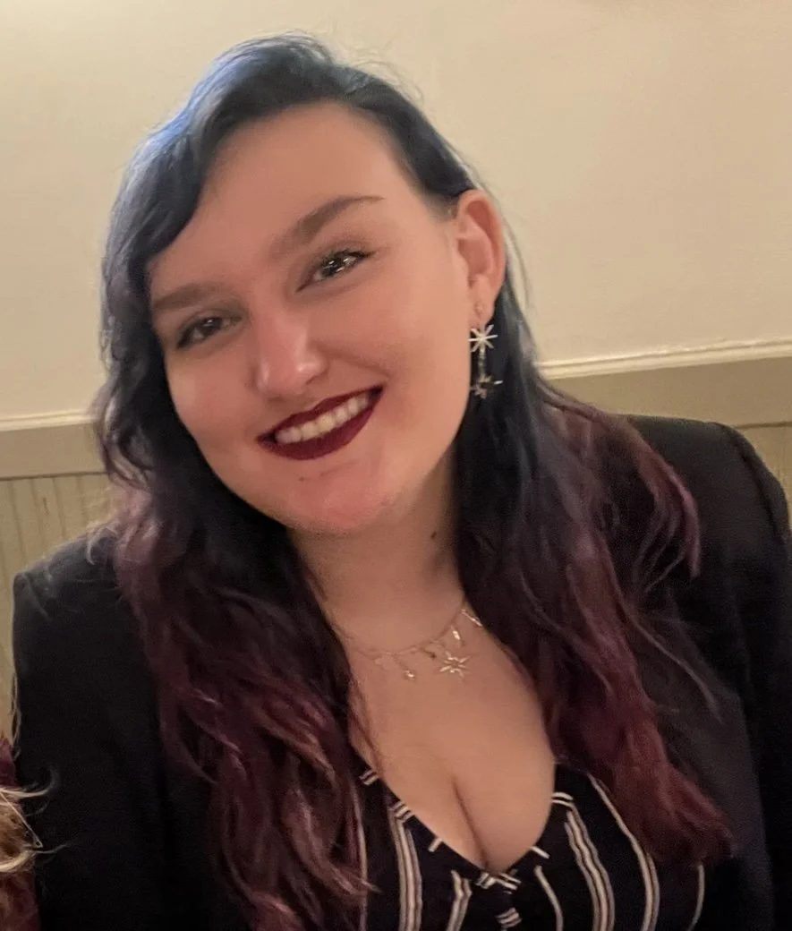 jordan valiquette wearing a black jacket and star earrings