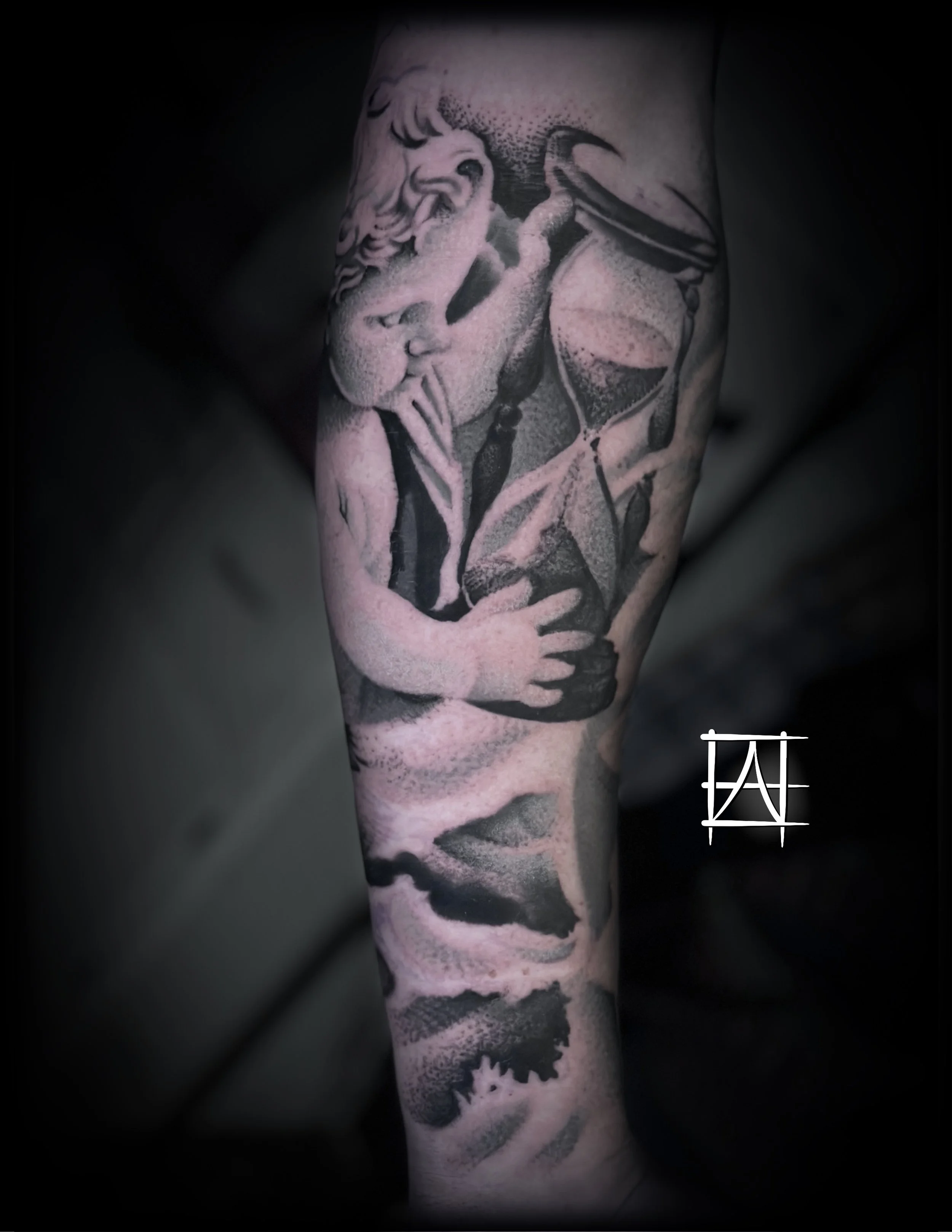 Close-up of a black and gray tattoo of an angel with curly hair holding an hourglass, on a person's arm.