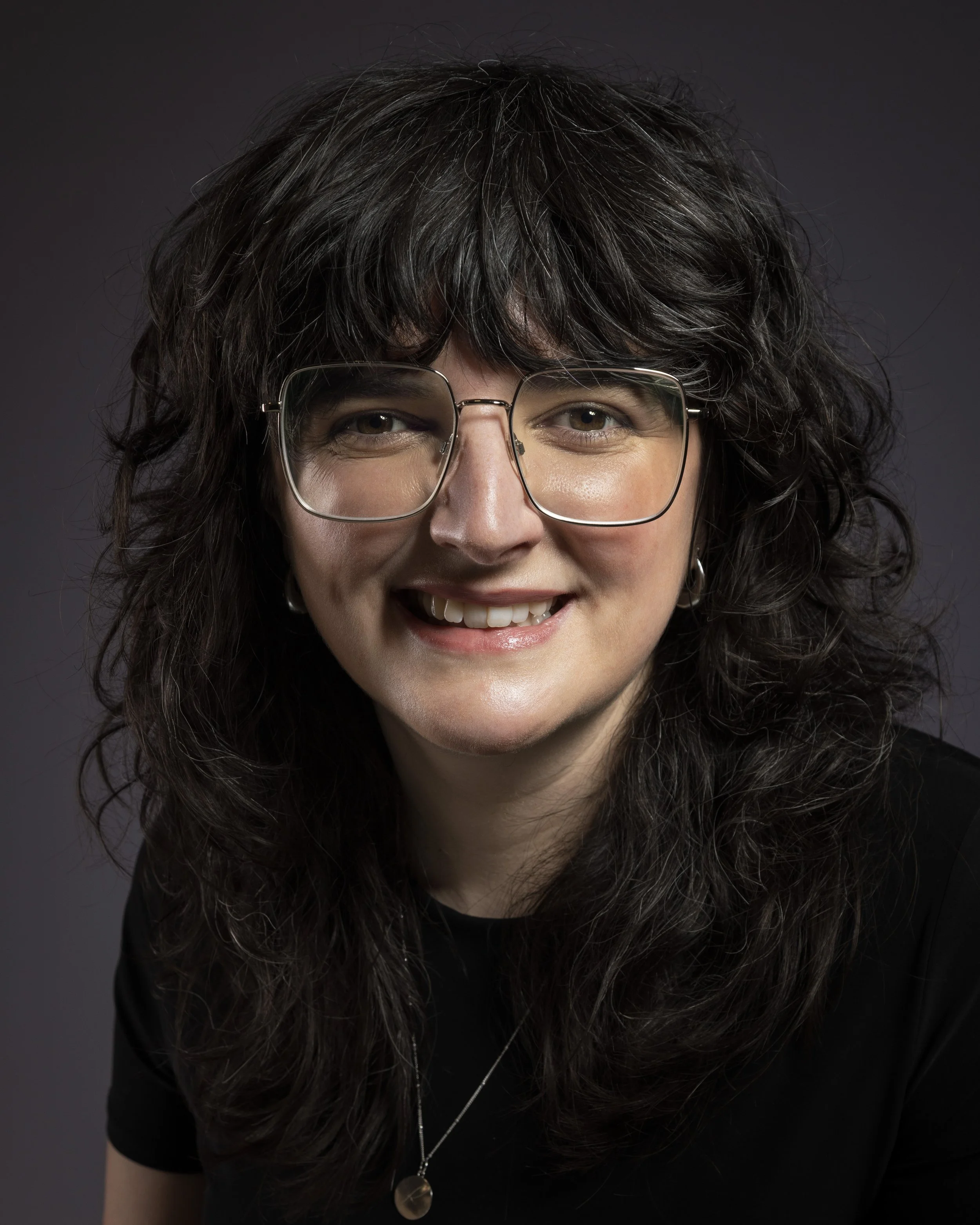 Photo of Rose, a woman with brown curly hair and silver jewellery
