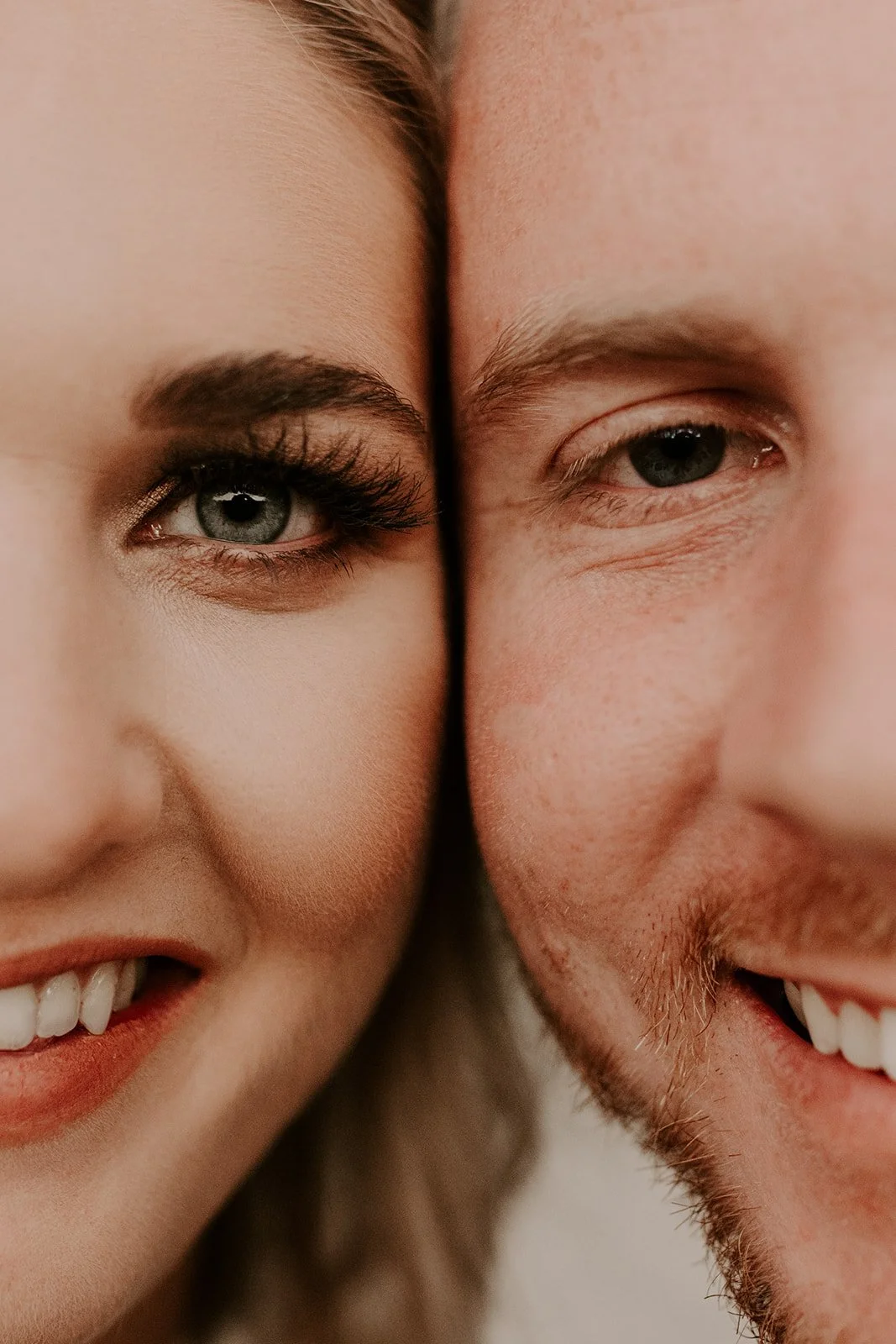 Close-up of a smiling woman and man with their faces touching, showing their eyes and part of their smiles.