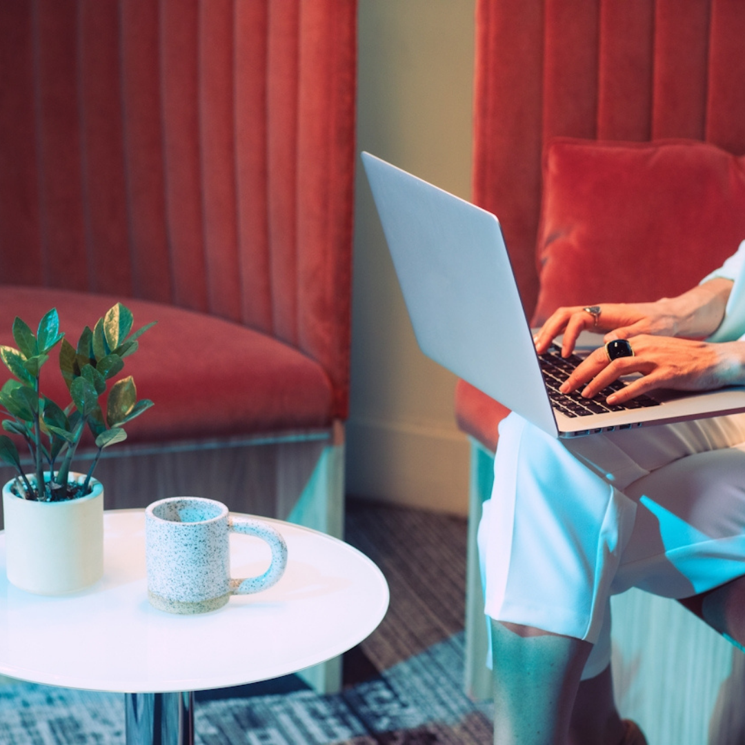 Person working on a laptop in a comfortable lounge setting, reflecting calm, sustainable SEO and content strategy work