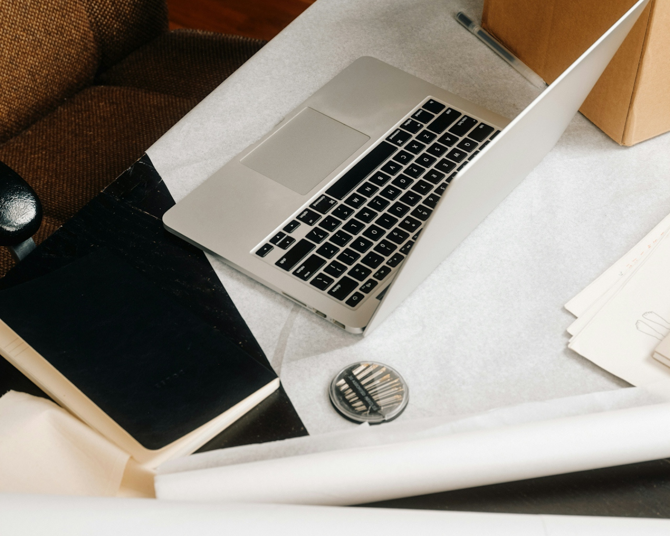 Minimal workspace with open laptop, notebooks, and creative tools used for content strategy and SEO planning