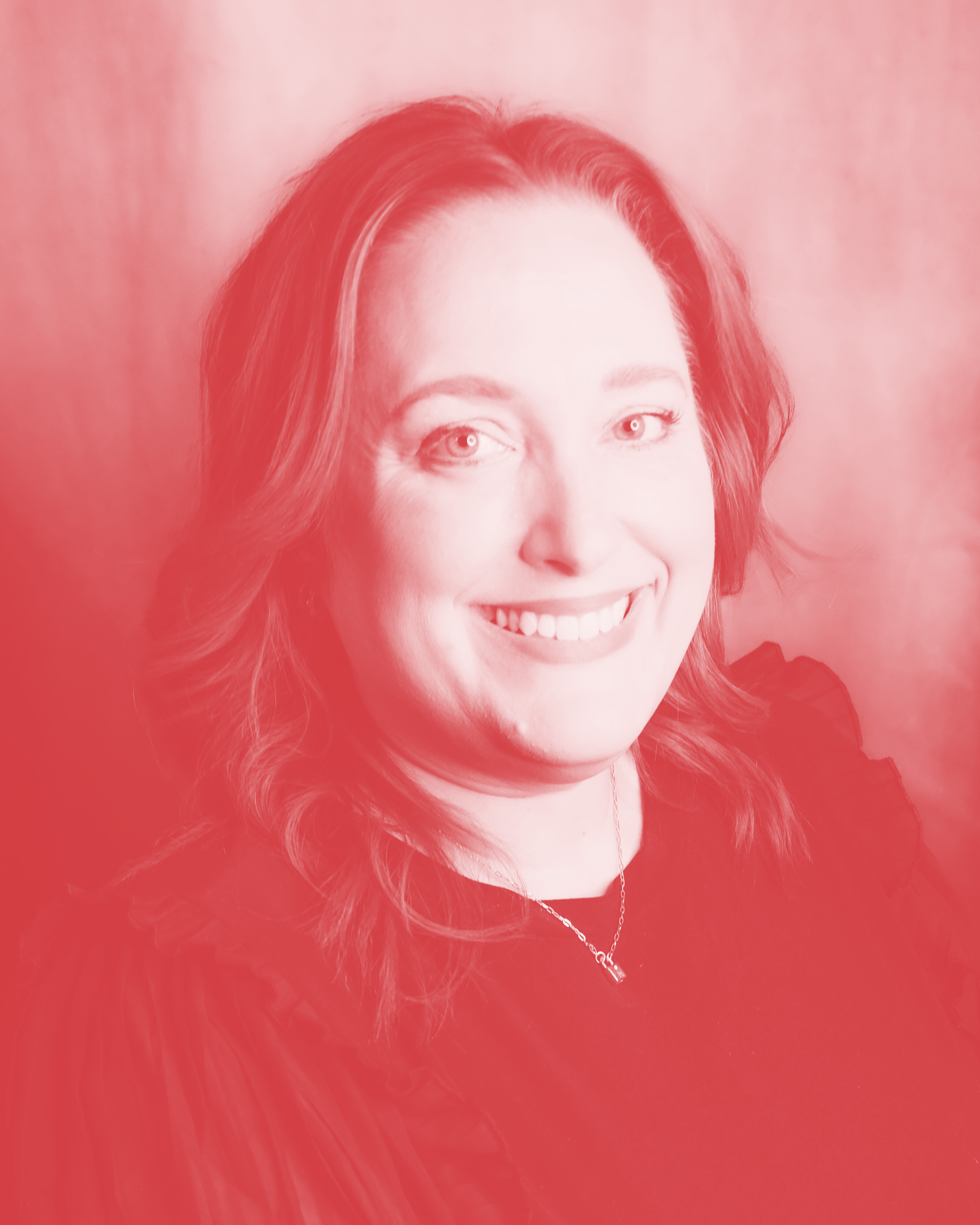 A woman with shoulder-length wavy hair, smiling at the camera, wearing a black top, with a pinkish-red overlay on the image.