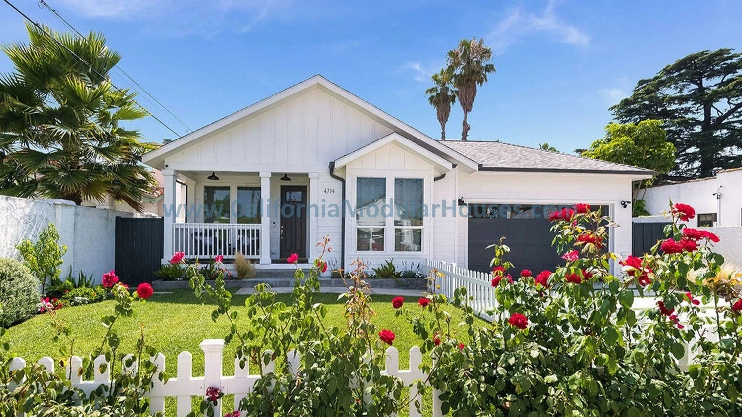 This is a single story modular home and this image shows the factory built covered porch along with the very tall windows throughout, including those in the bay window.  