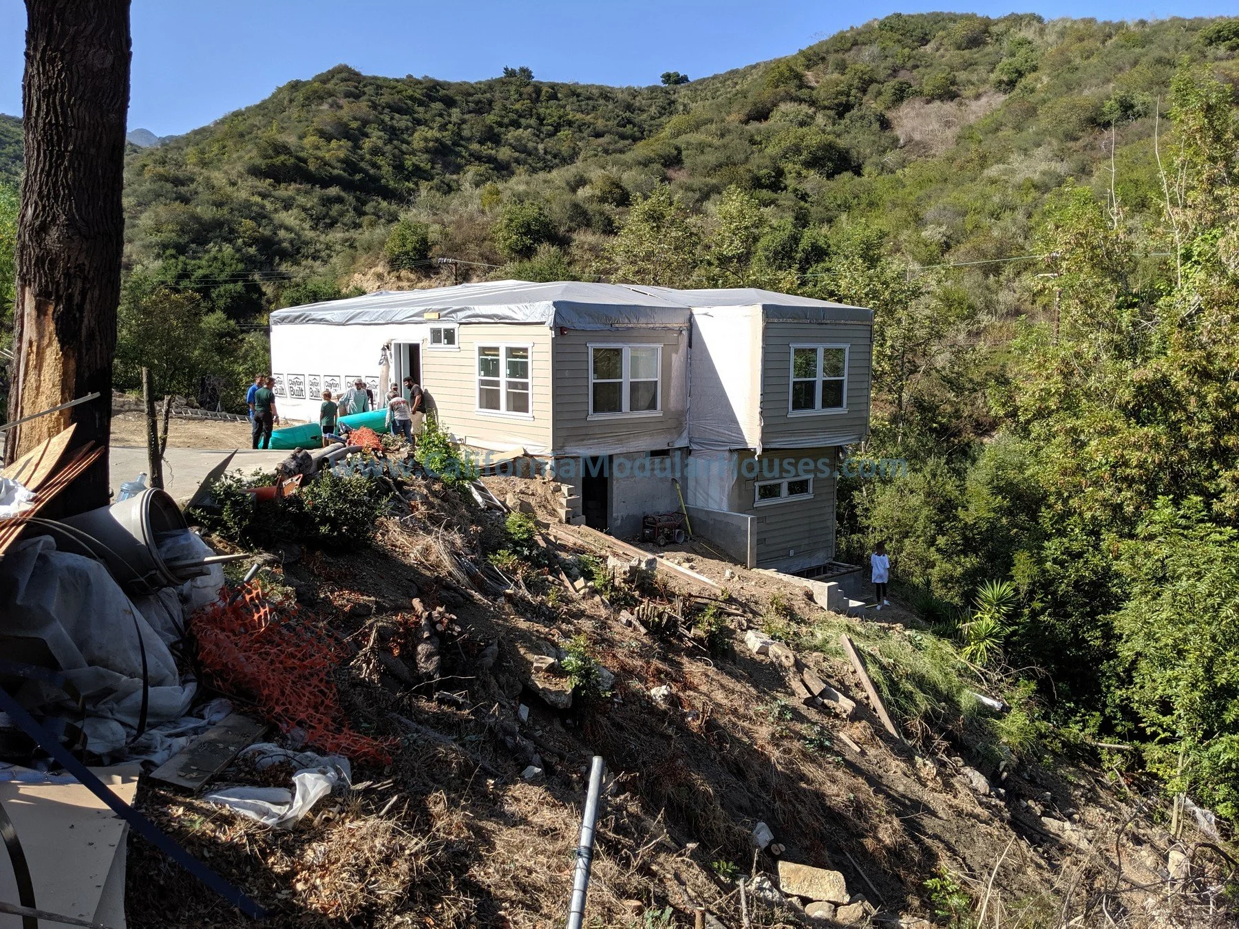 Construction of a house on a hillside surrounded by trees and mountainous terrain.  City of Santa Barbara, Santa Barbara County, CA.  Modular Home CA, California Modular Homes, Prefab Modular Homes California, California Modular,