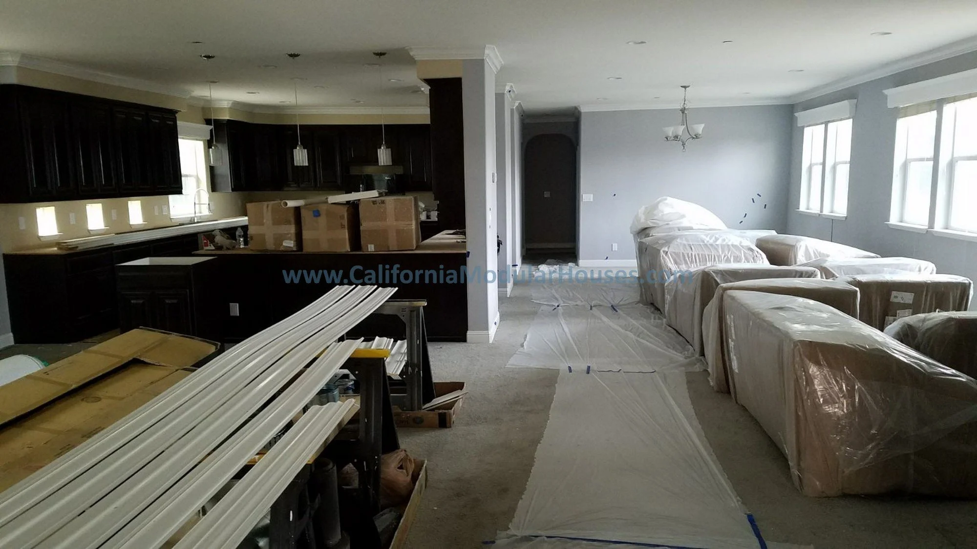 This shows how the modular home was delivered on the left with ship loose materials that are installed after the flooring and the client was excited and got some furniture delivered.  The home has recessed lighting and fire sprinklers.  