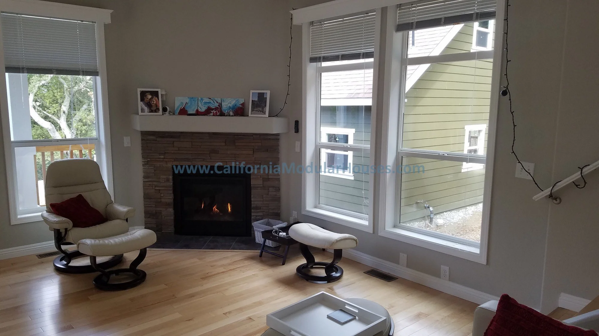 Living room with a site installed gas fireplace, large windows.   The windows on both sides of the fire place let in lots of light and make that area of the room the focal point.   Pre-Fab.  Orinda, CA.  