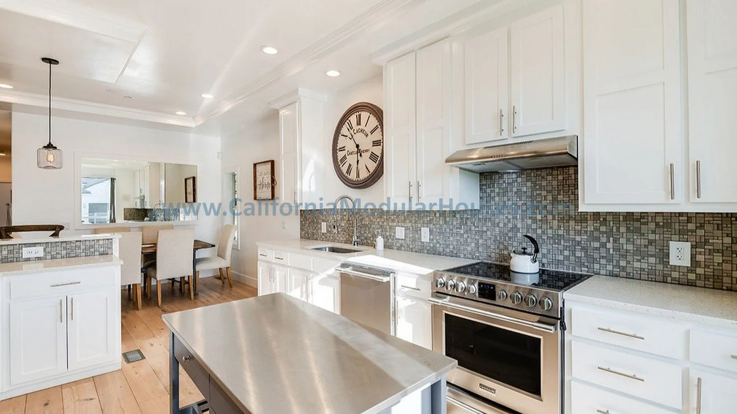Bright modern kitchen with white cabinets, stainless steel stove, tiled backsplash, and a kitchen island inside of this Factory Built Home.  Los Angeles, California.   