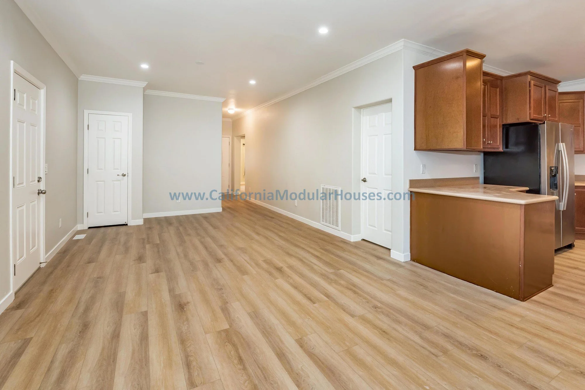 Living room of a prefab modular, brown wooden floors, cherry oak cabinets.