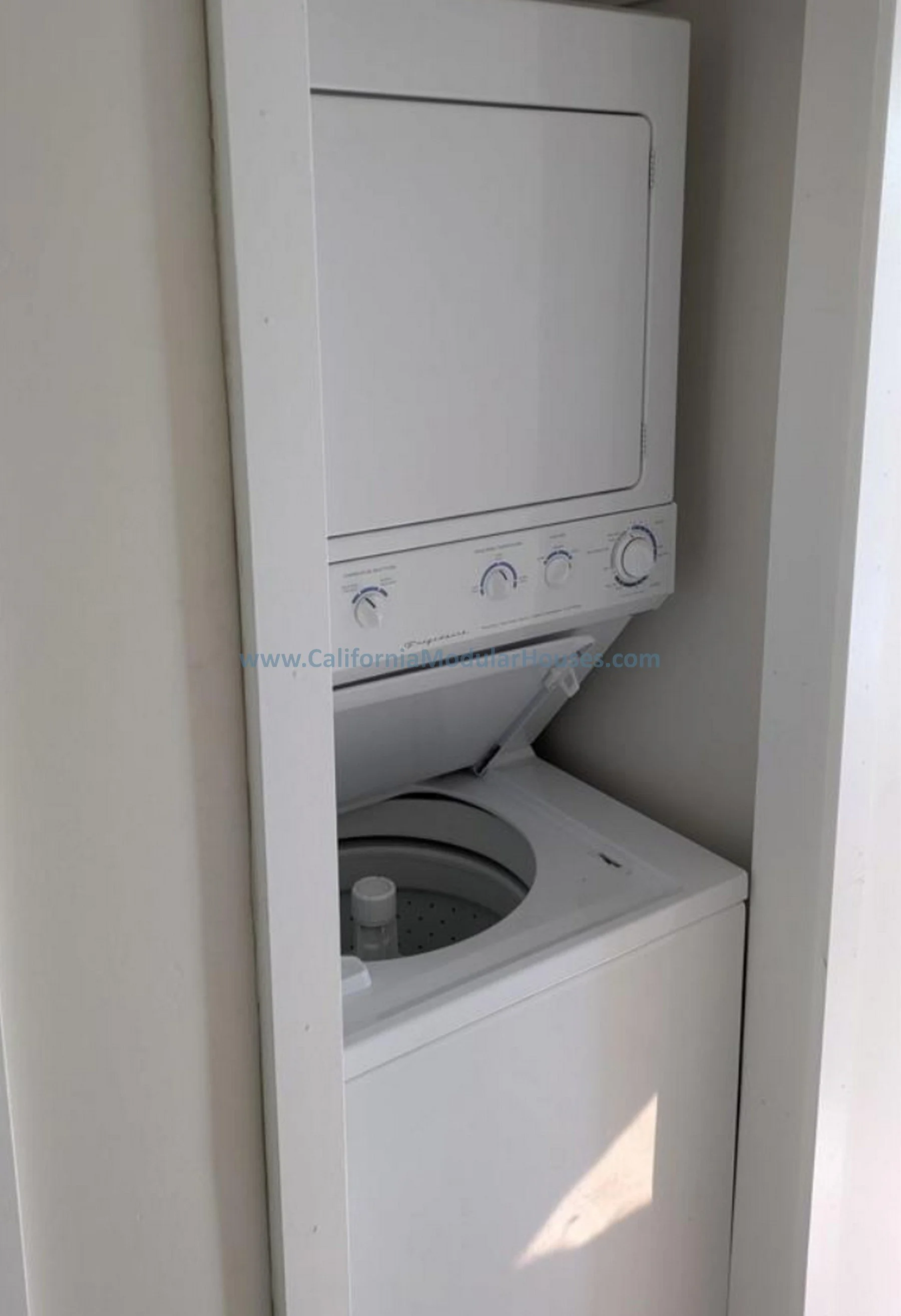 Prefab Modular ADU, Oceanside CA.  Accessory Dwelling Unit.  California Modulars.  A compact stacked washer and dryer unit installed in a small closet or alcove, with the dryer on top and the washing machine below.