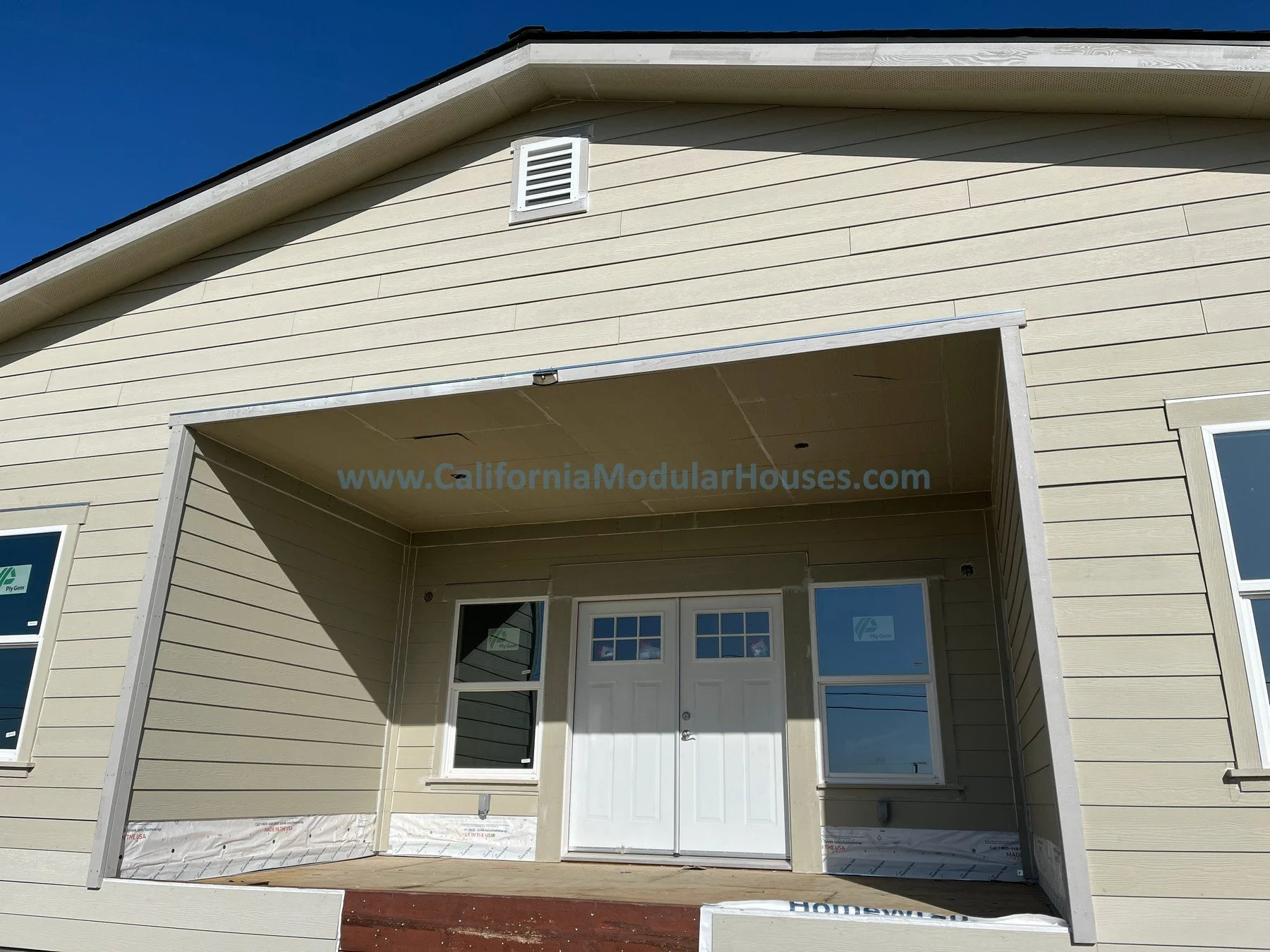 newly constructed beige modular house with a large porch, Ranch style modular home that has 3 bedrooms and 2 bathrooms California modular modulars CA prefab exterior image K
