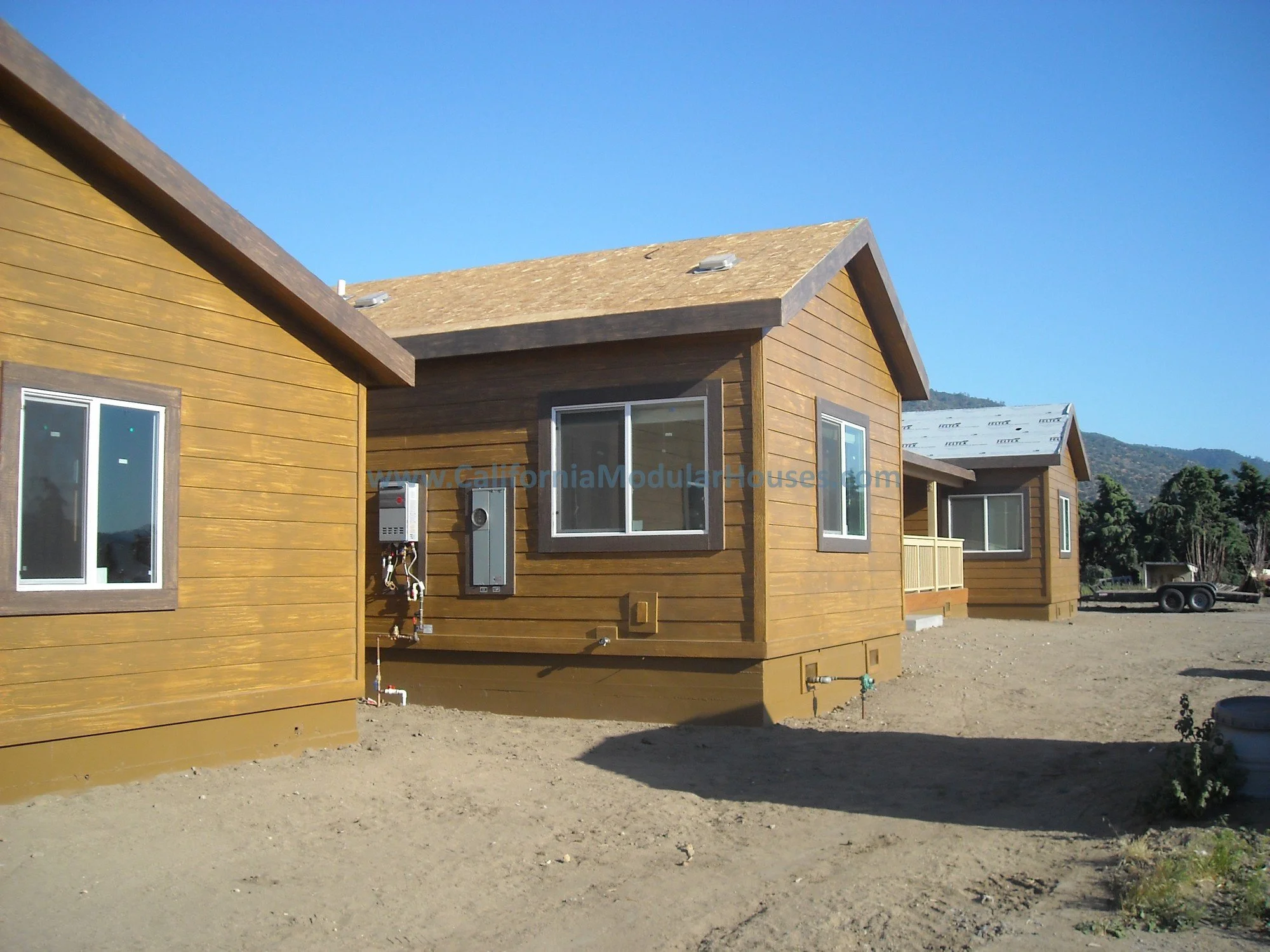 This Factory Built Home shows the electrical panel as well as exterior mounted tankless water heaters (one on each side of the home, which were later enclosed).  Kern County, California.  