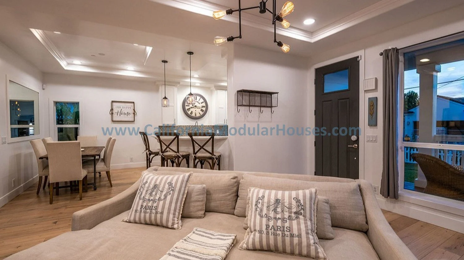 Living room that is nice and large, right at the front door with huge windows on the front, showing right into the dining area and the barstool area so everyone is together wherever they choose to sit in this modular home.  