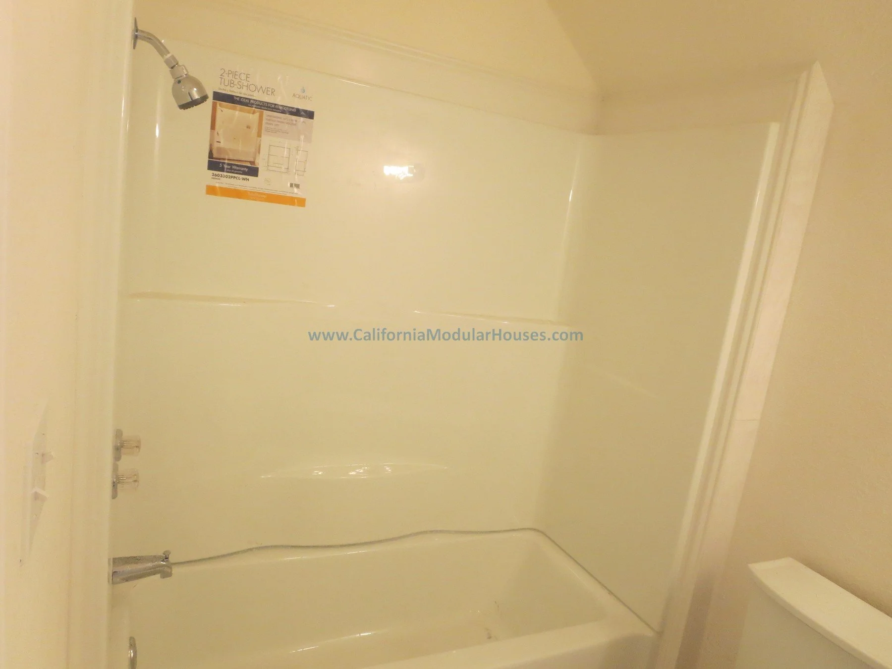 California modular home.  Prefab.  Modulars.  Napa, CA.  California Modular House.  Empty bathtub with showerhead, controls, and a waterproof wall panel. There is a partially visible toilet in the corner.