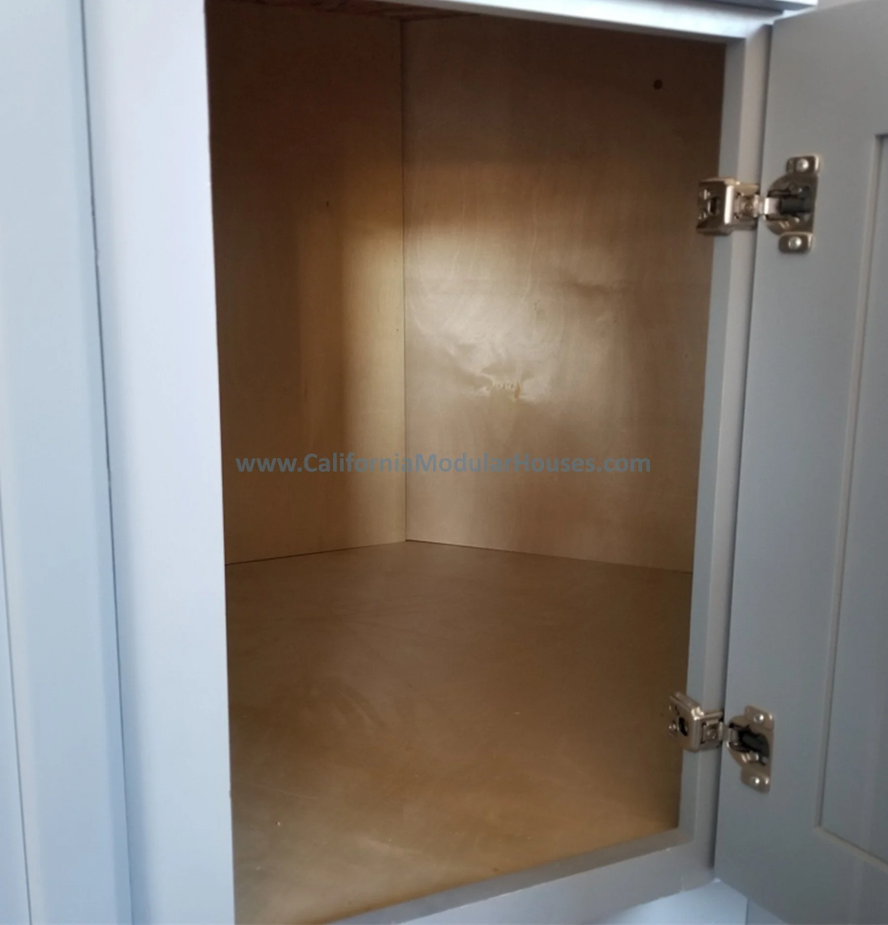 Empty wooden cabinet inside a light gray metal locker with open door. Interior picture of Accessory Dwelling Unit Contra Costa County, CA  Modular granny flat.  California.   