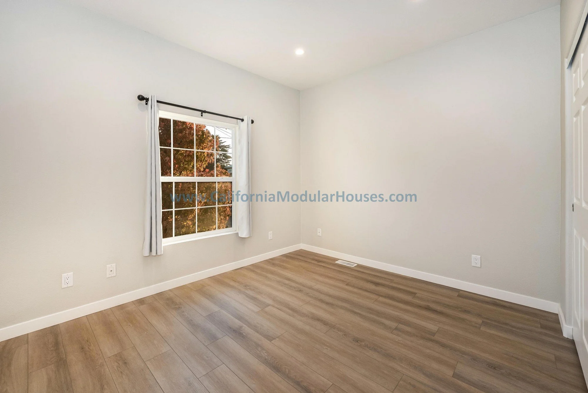French oak floors of a prefab modular two-story home, bright light windows.