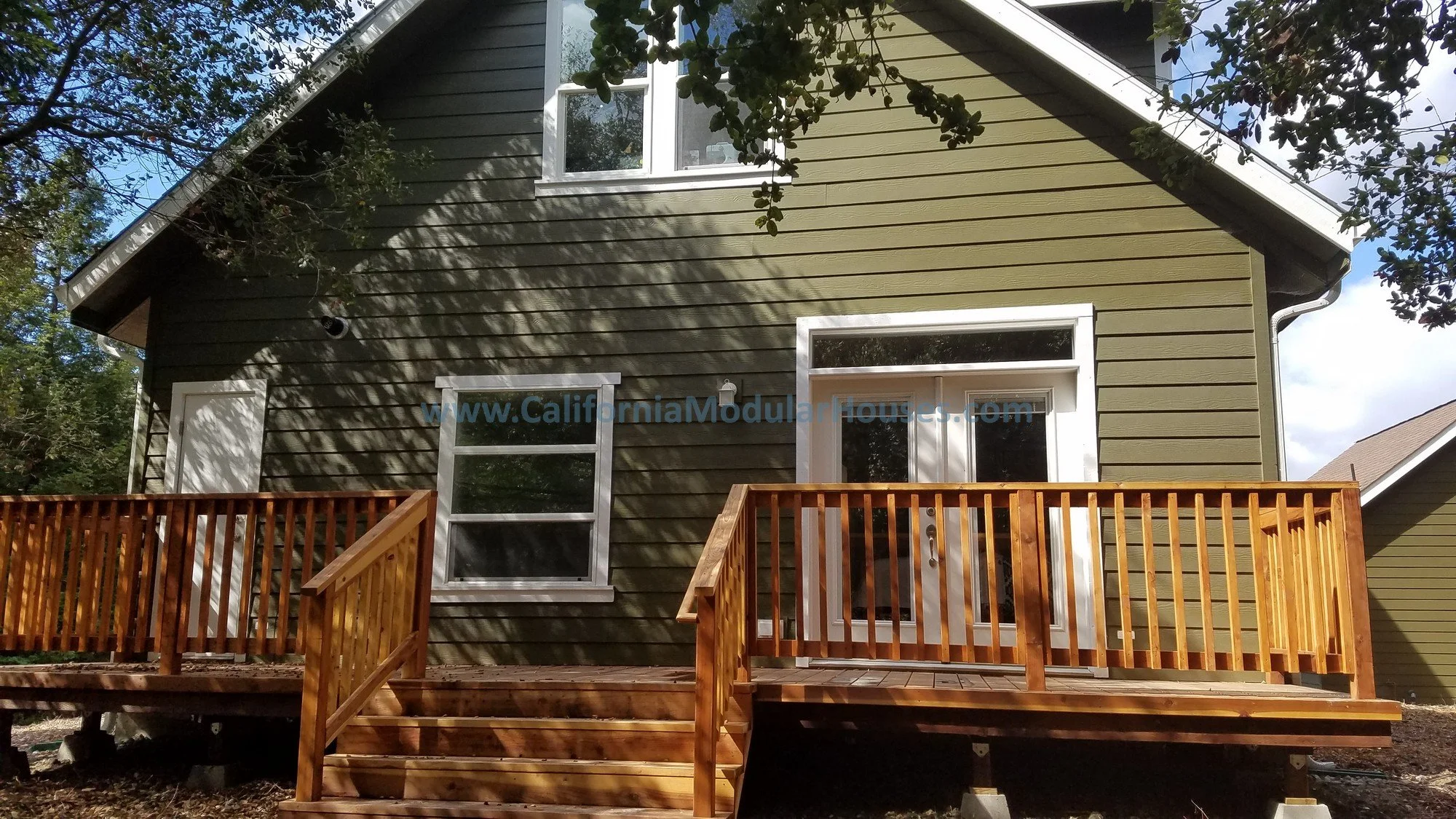 This uncovered wooden deck was built on-site after the home was delivered, can be as large or small as one would want.  The windows and the French Doors leading out to the rear of the home sure make it look great!  Modular Home.  