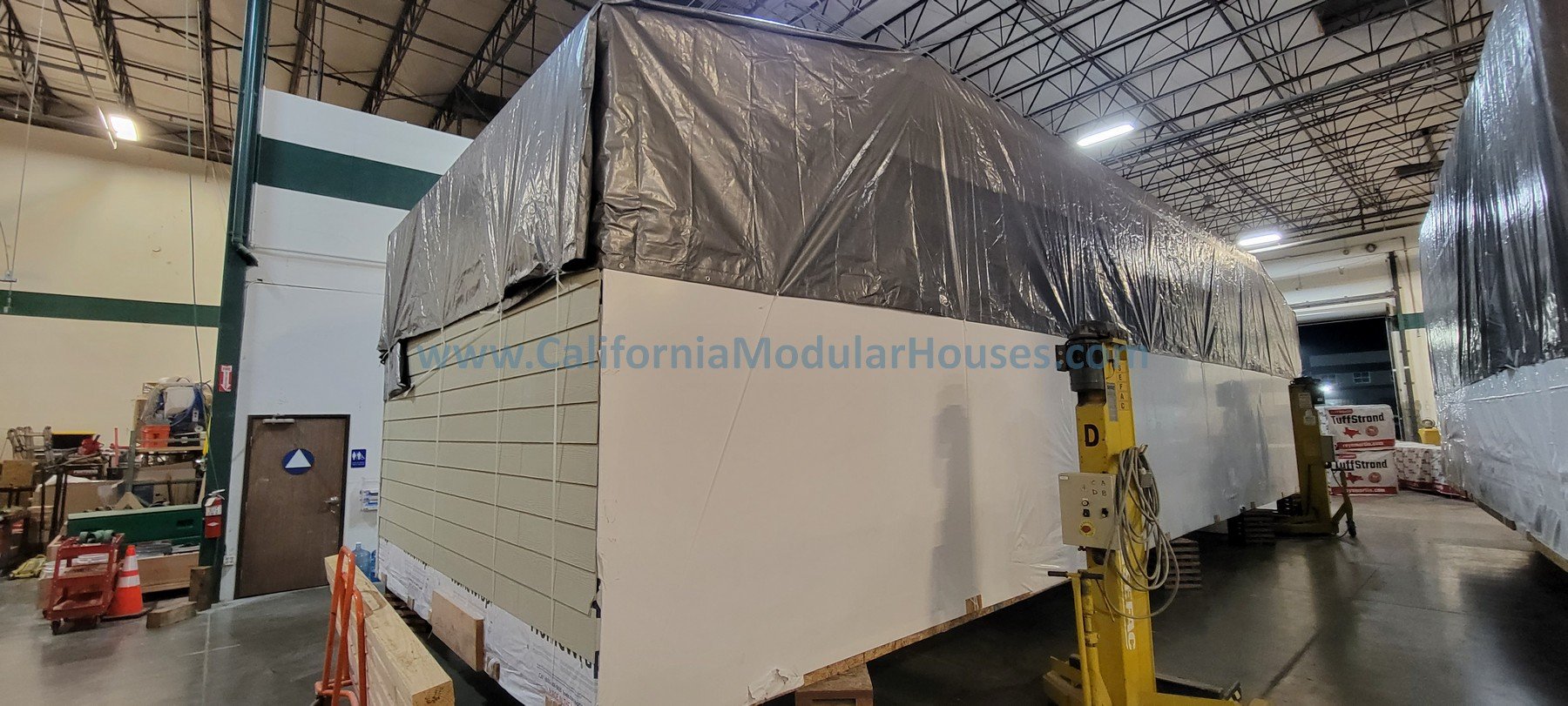 Wooden floor framing under construction in the factory.  Single Story Ranch housing under construction.  Modular prefab.  California Modular.  CA Prefab. 