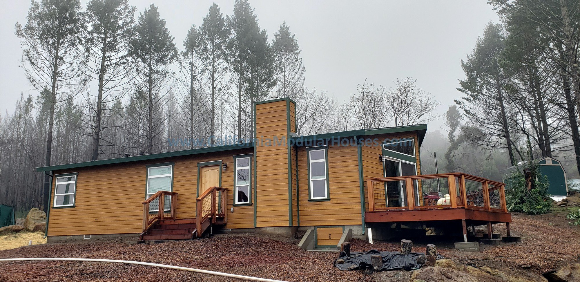 This modular home on a raised concrete stem wall foundation shows the front site built deck for entertaining and spending beautiful days & evenings to enjoy the view.   