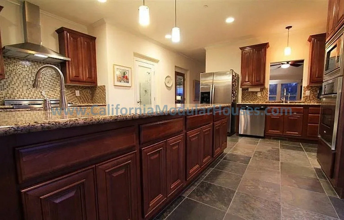 Kitchen with dark wood cabinets, granite countertops, tiled backsplash, stainless steel appliances, and tiled floor. Recessed and hanging lighting