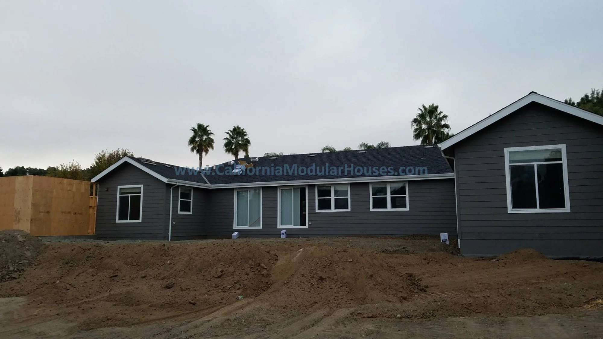 This is the rear of this modular home, the grading around the house is almost done and the garage is built built, the home features many windows to allow for natural light throughout the home.  