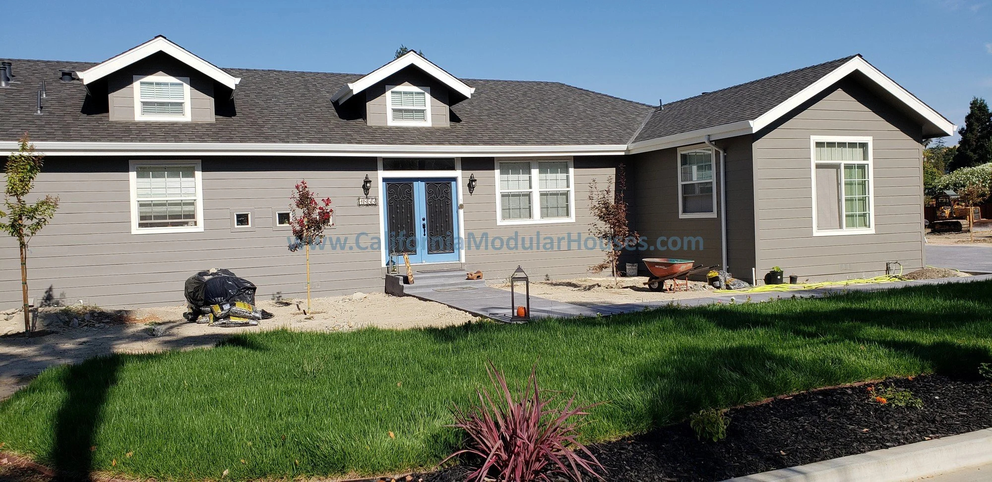 This Factory Built Housing model has two dormers on the front.  The rockwork trim was done on-site.  It features lap siding and a limited lifetime composition shingle roof.  