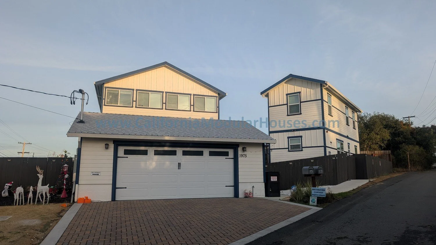 Two modern two-story homes with white and blue siding.  There is a main residence and an ADU, both are modular.  Modular home, modular Accessory Dwelling Unit.  Crockett, CA.  Contra Costa County.  Modulars. 