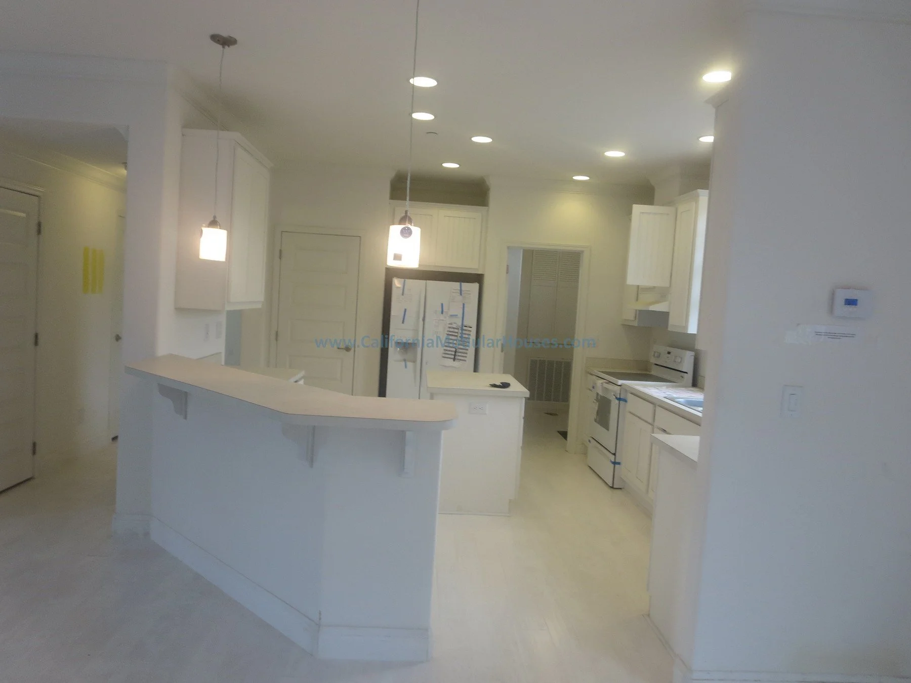 California modular home.   Unfinished attic.  New prefab modular house in Napa, CA.  Empty white kitchen with pendant lights, appliances, and a breakfast bar.