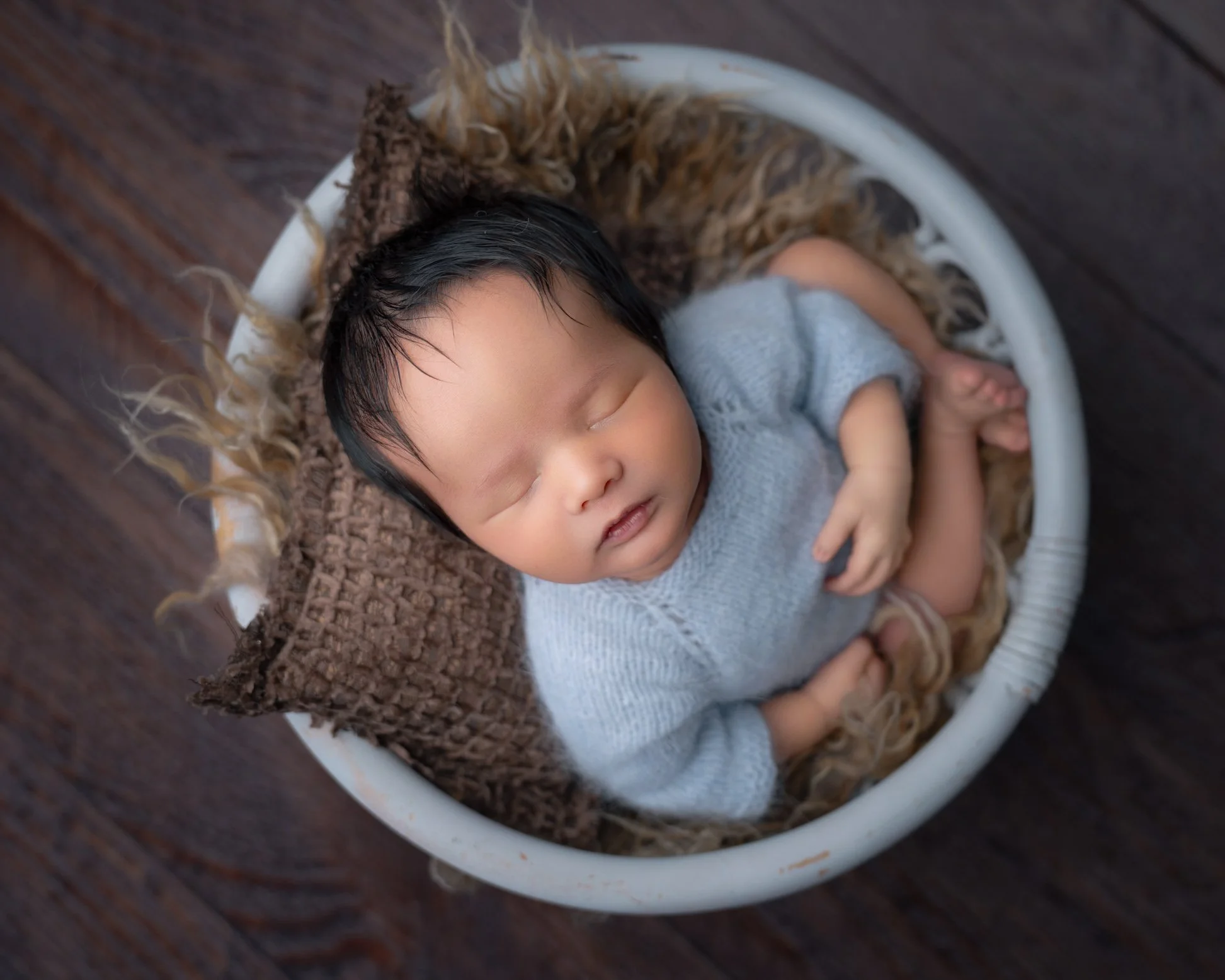 Posed newborn baby in a basket
