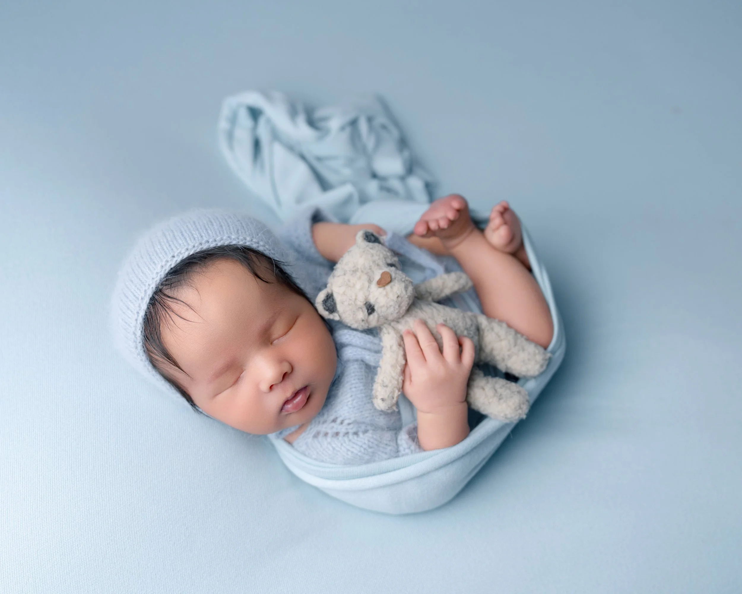 Newborn baby posed with teddy bear