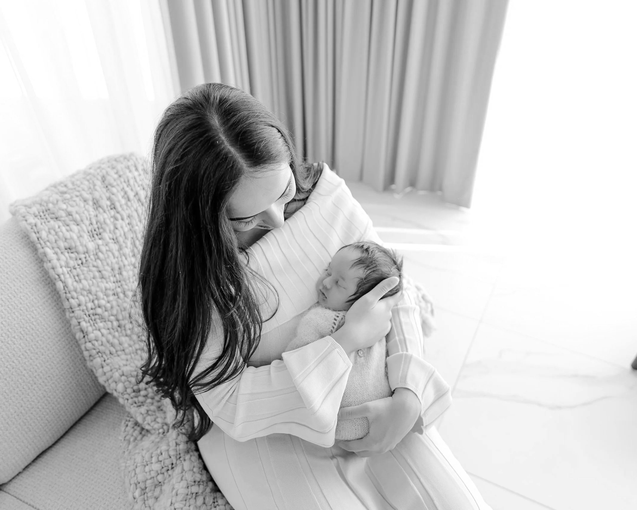 Mum cuddling her newborn baby at home