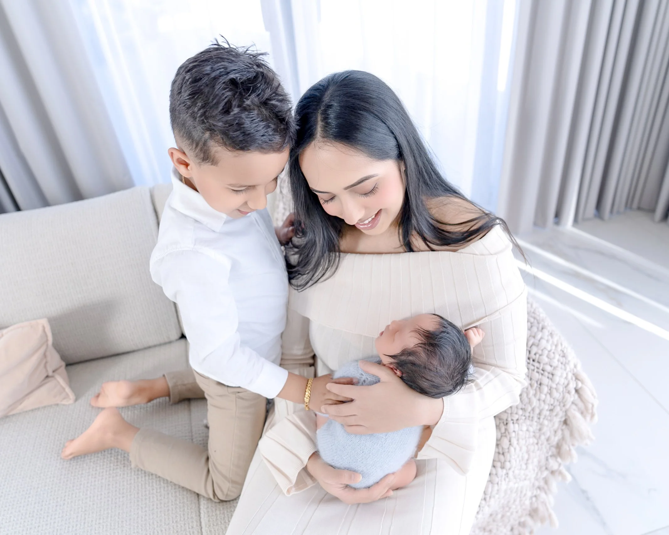 Mum with newborn baby and older sibling during an Auckland in-home newborn photography session.