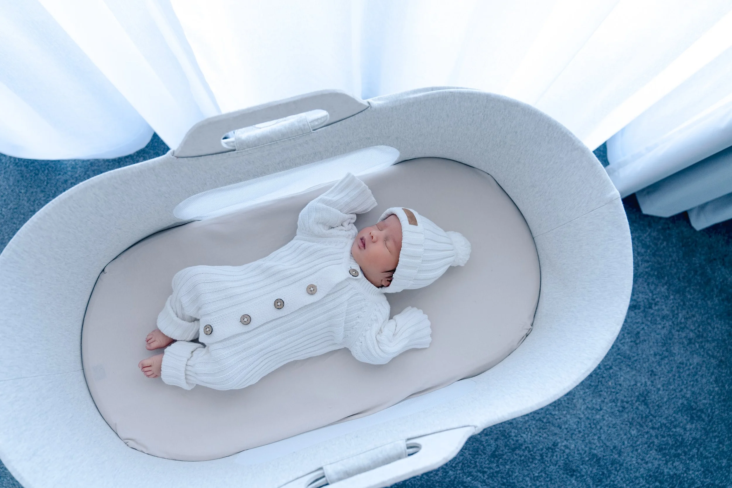 Newborn baby resting in a bassinet at home during an Auckland newborn photography session.