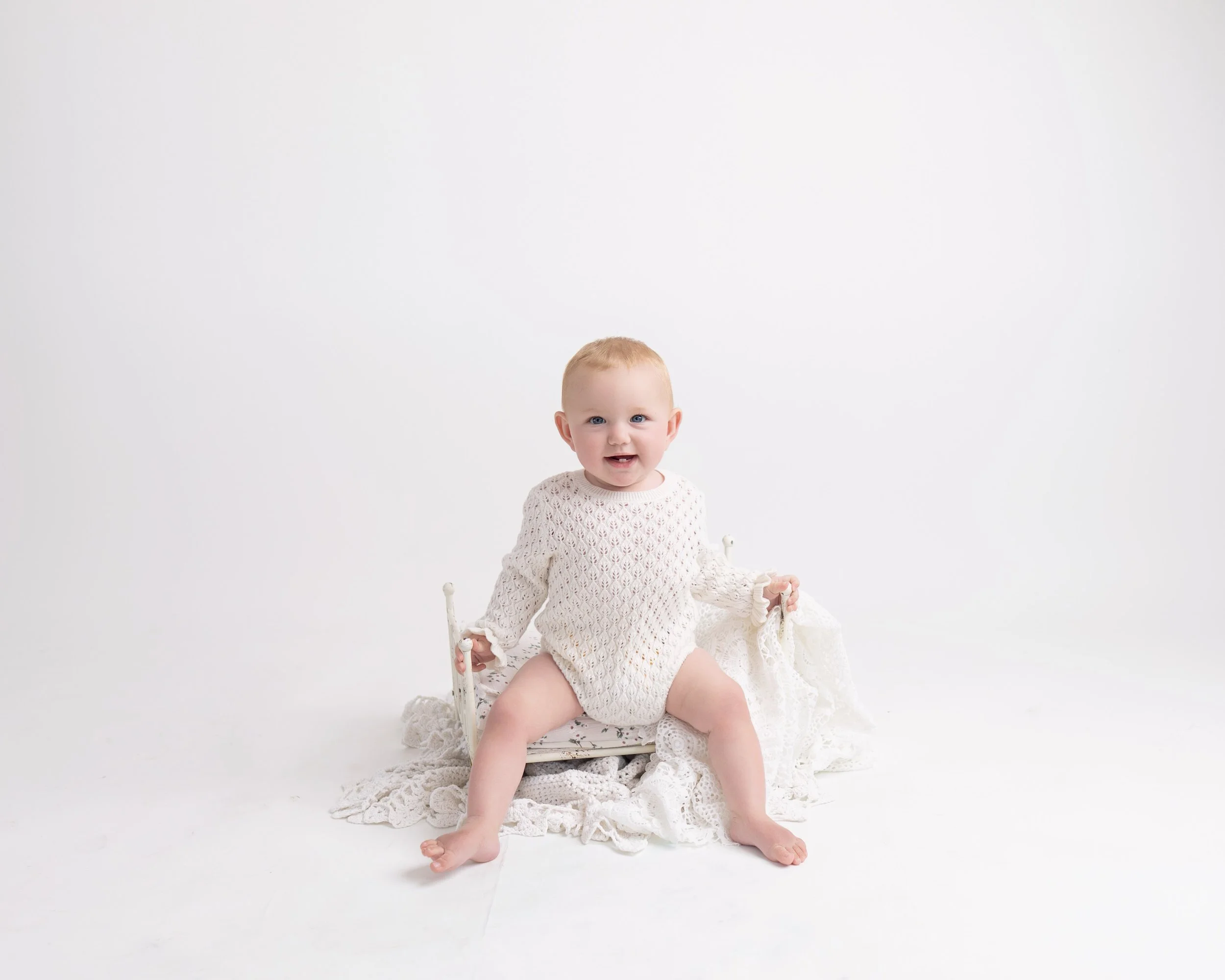 Smiling baby sitting independently during a simple, natural milestone photography session in South Auckland.