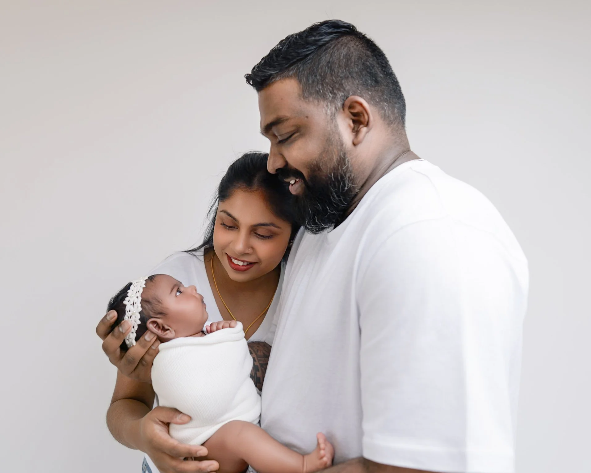 Mum and Dad with their baby during the studio part of a split newborn photography session in Auckland