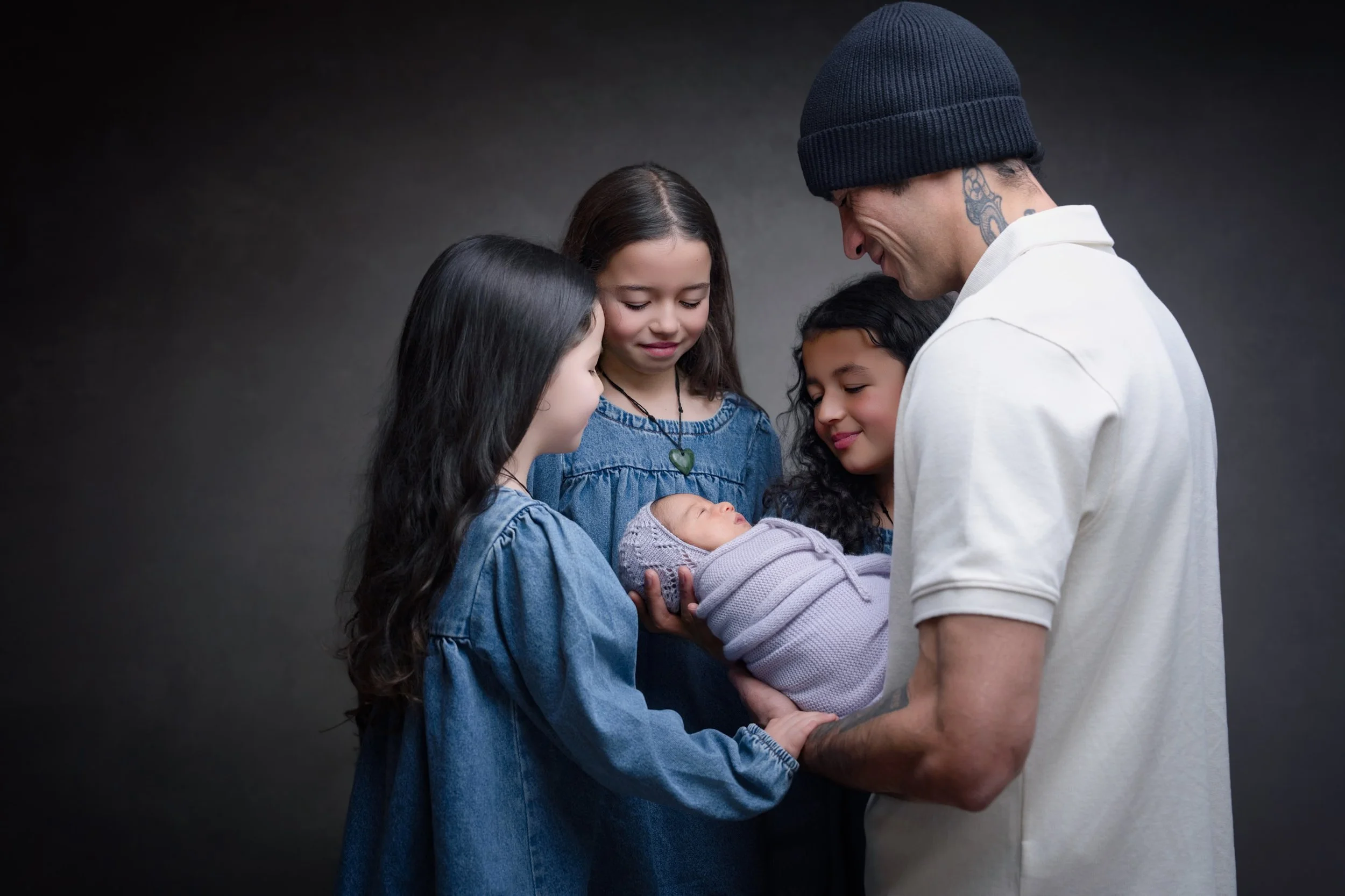 Parents and three older siblings with their newborn baby during an Auckland newborn photography session.