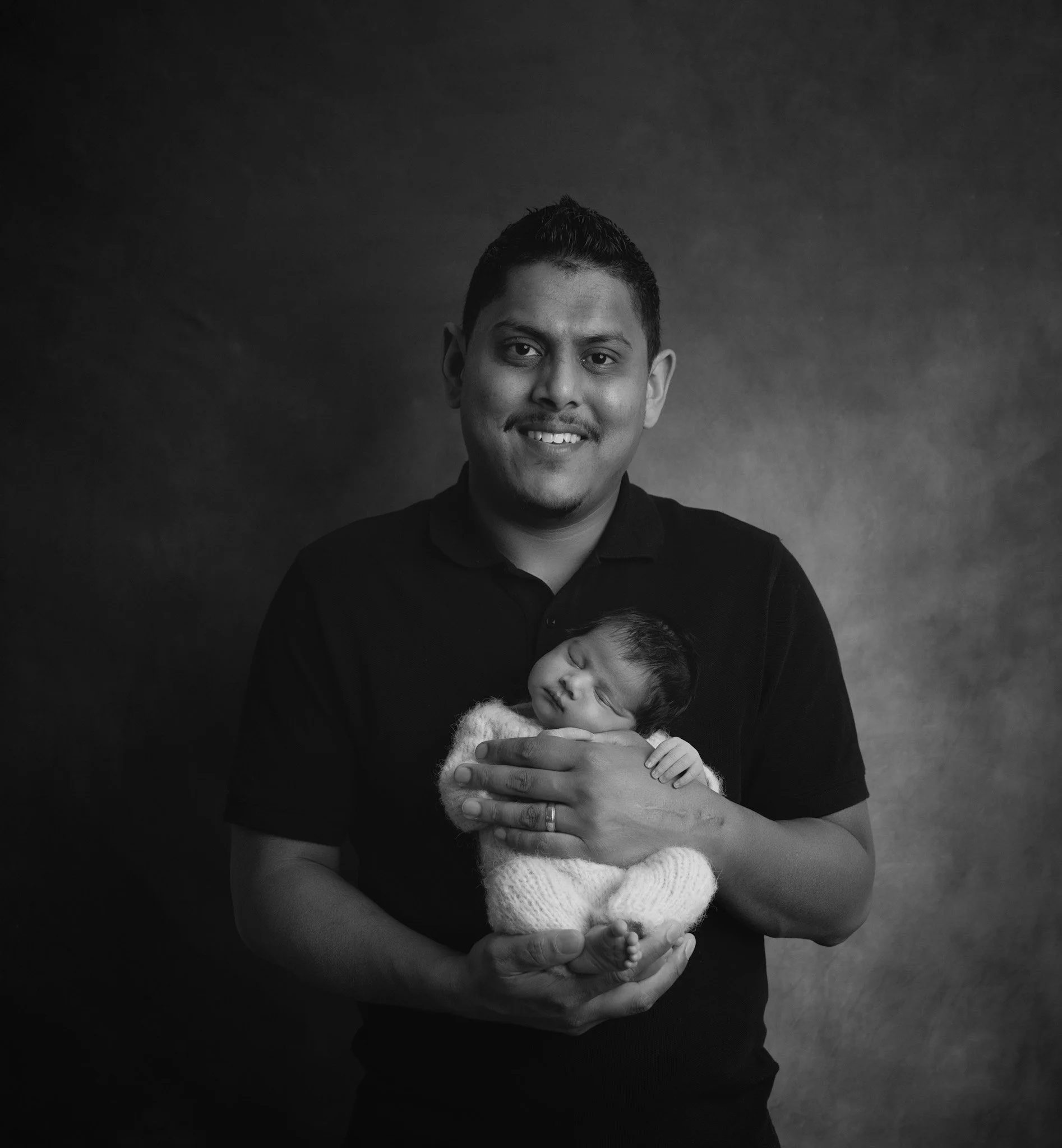 Father holding his newborn baby during an Auckland newborn photography session.